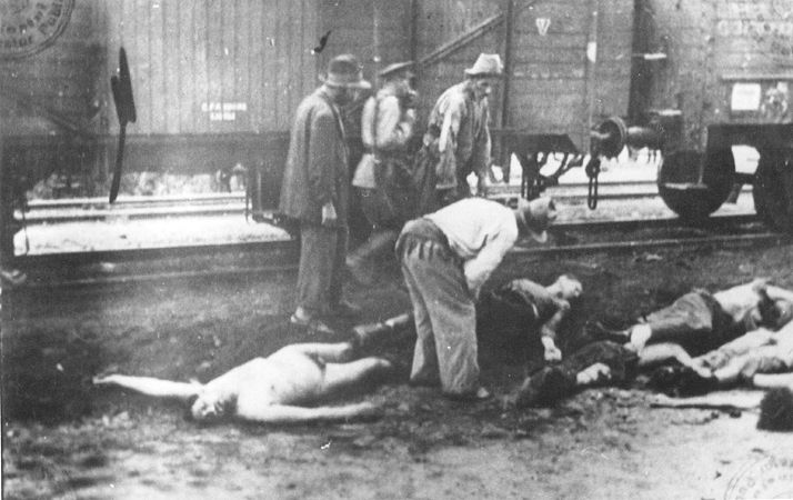 Romanian guard walks past Gypsies removing bodies from the Iasi-Calarasi death train